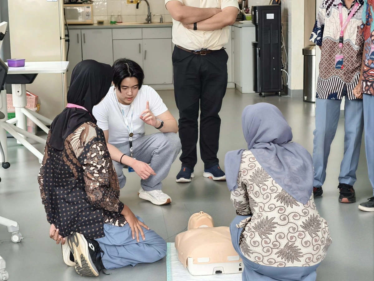 Beatkeepers coaching two students as they practise chest compressions